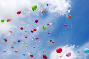 Colorful balloons flying on blue sky, copy space