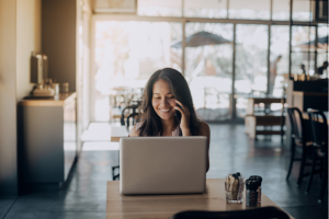 happy asian woman works from home on laptop