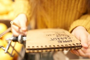 Child with grocery list in grocery cart