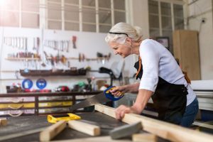 Senior woman doing woodwork in a workshop.