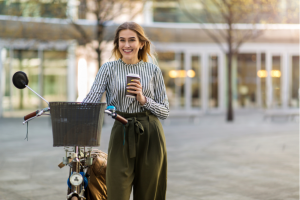 Attractive young woman standing with her bicycle in the city