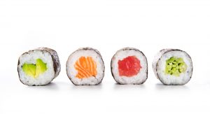 Four maki rolls in a row with salmon, avocado, tuna and cucumber isolated on white background.