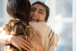 Two happy mixed-race women hugging each other