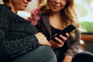 Pregnant woman and partner looking at a phone