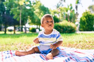 Baby sitting on picnic blanket in the park