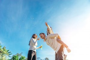 Happy family blowing bubbles together in a park