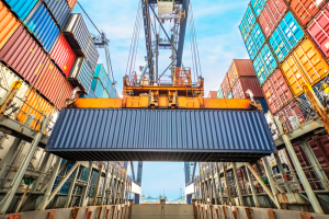 Shipping container lifted by crane at port