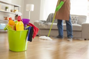 Man holding mop and plastic bucket.