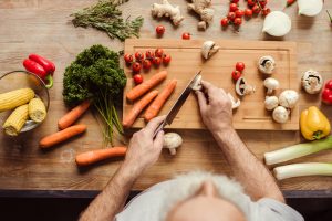 Older man chopping vegetables