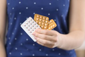 Woman holding contraceptive pills